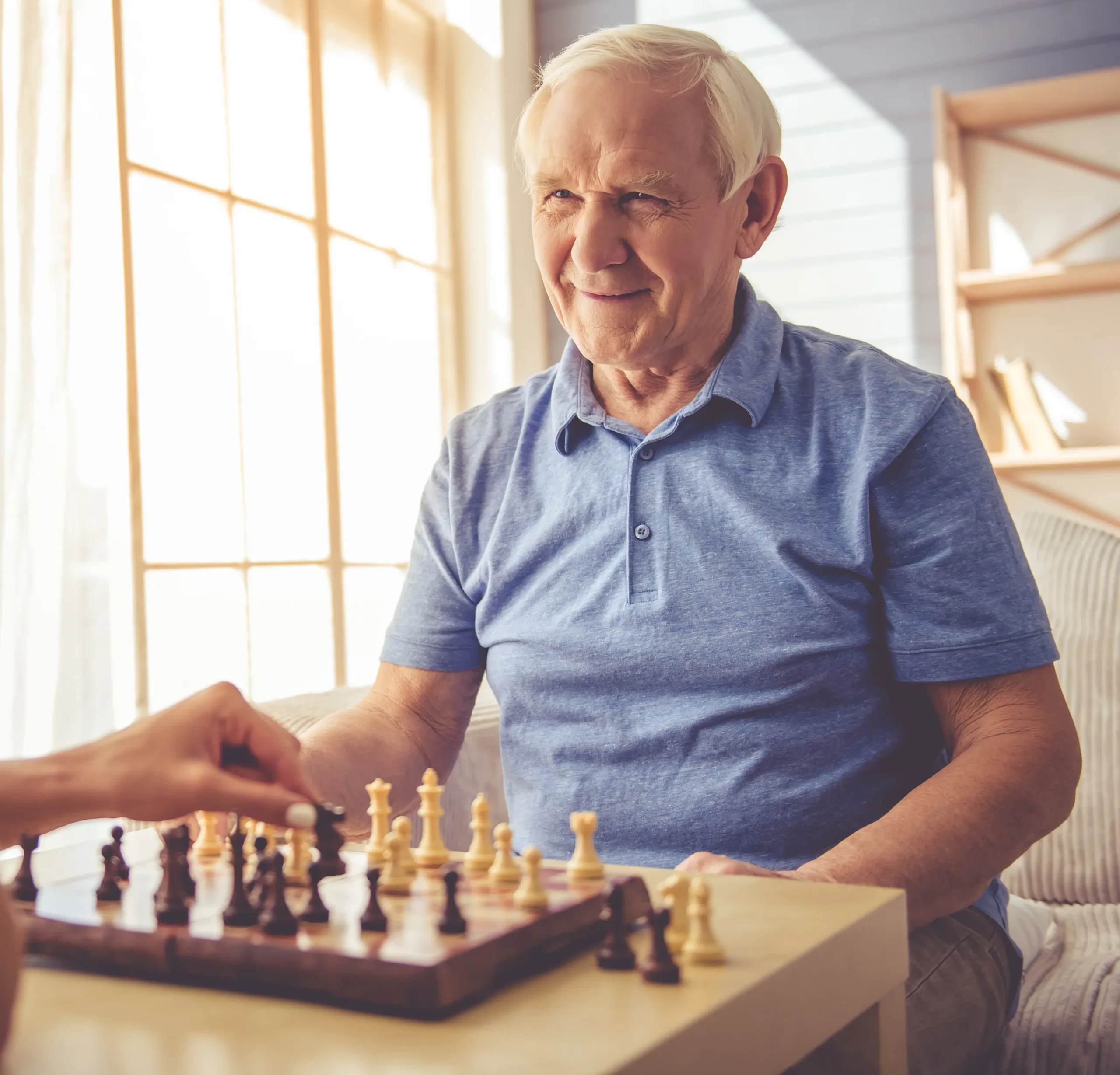 Man with dementia playing chess with a team member from brigade